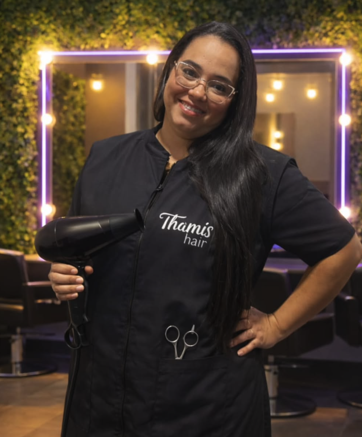 Thamy, especialista em beleza e cuidados capilares, sorrindo em seu salão